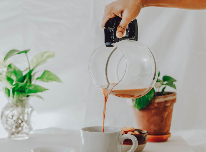 Pouring coffee into a cup from a kettle